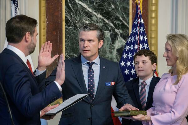 Vice President JD Vance, from left, swears in Pete Hegseth to be Secretary of Defense as his wife Jennifer Rauchet holds the Bible and Hegseth's son watches in the Indian Treaty Room of the Eisenhower Executive Office Building on the White House campus in Washington, Saturday, Jan. 25, 2025. (AP Photo/Rod Lamkey, Jr.)