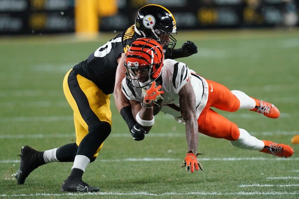 Cincinnati Bengals wide receiver Ja'Marr Chase (1) picks up a first down defended by Pittsburgh Steelers linebacker Alex Highsmith (56) during the first half of an NFL football game in Pittsburgh, Saturday, Jan. 4, 2025. (AP Photo/Matt Freed)