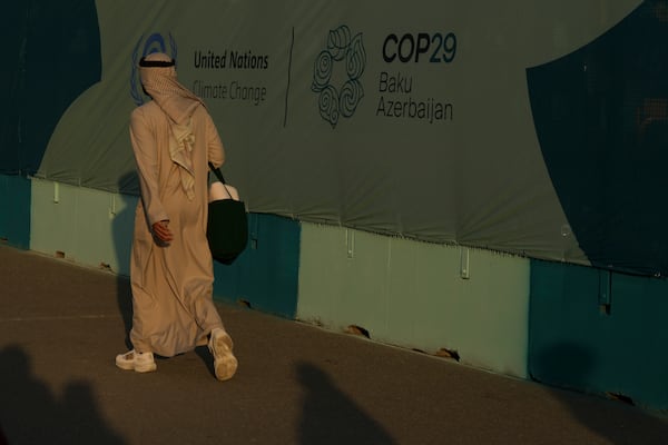 A person walks past a sign for the COP29 U.N. Climate Summit, Friday, Nov. 15, 2024, in Baku, Azerbaijan. (AP Photo/Peter Dejong)