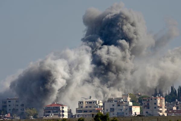 Smoke rises between buildings hit in an Israeli airstrike in Burj al-Shamali village, as seen from Tyre city, south Lebanon, Friday, Nov. 22, 2024. (AP Photo/Hussein Malla)