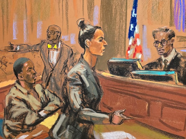 In this courtroom sketch, Assistant United States Attorney Christy Slavic, standing center, speaks during a hearing for Sean "Diddy" Combs, left, as Judge Arun Subramanian, right, presides in federal Court, Friday, Nov. 22, 2024, in New York. Attorney Tony Riccio is shown standing background center. (Jane Rosenberg via AP)