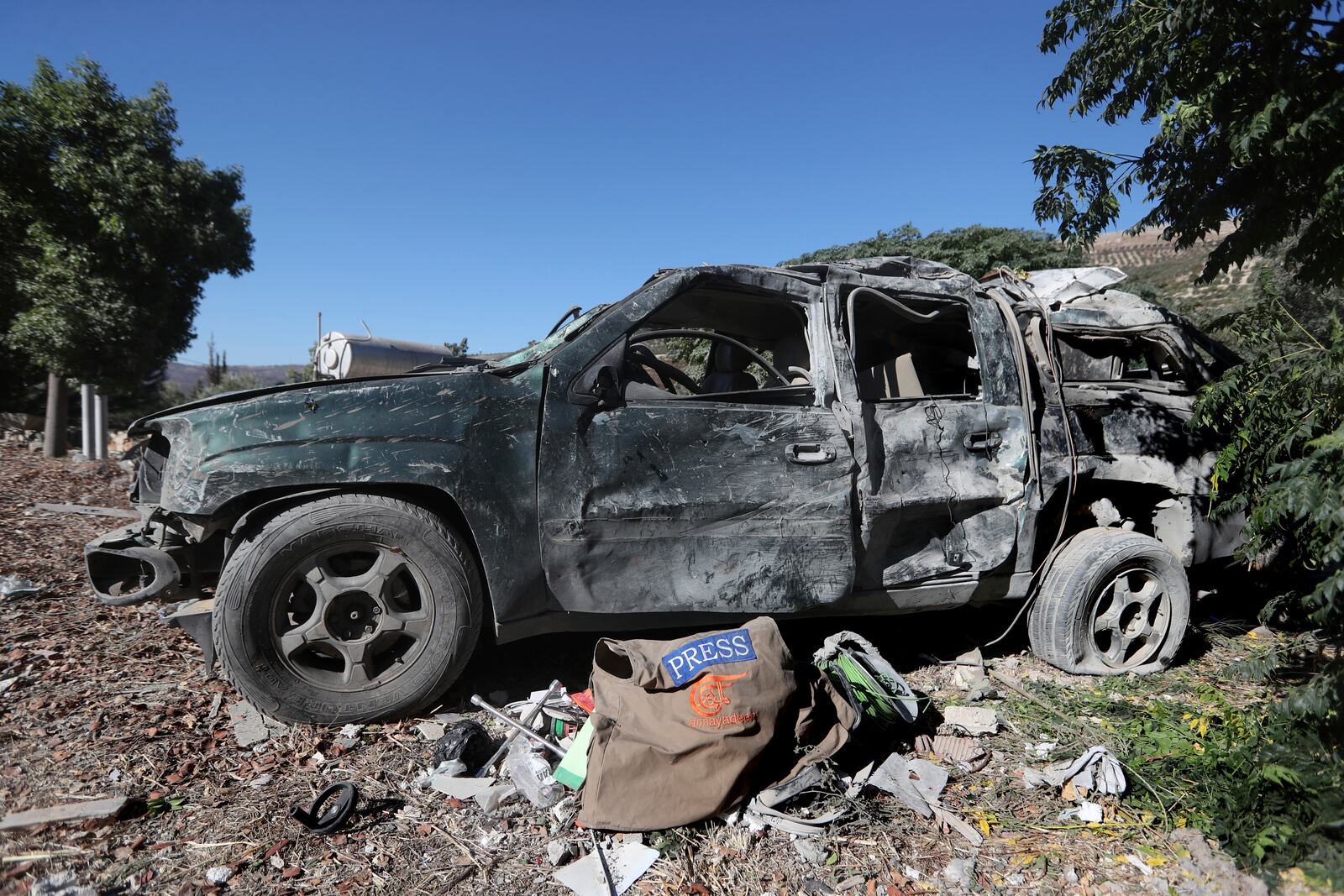 Journalists' items on the ground next to a destroyed vehicle, at the site where an Israeli airstrike hit a compound housing journalists, killing three media staffers from two different news agencies according to Lebanon's state-run National News Agency, in Hasbaya village, southeast Lebanon, Friday, Oct. 25, 2024. (AP Photo/Mohammed Zaatari)