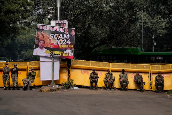 Security officials stand during a protest against Indian billionaire Gautam Adani and Indian Prime Minister Narendra Modi, after Adani was indicted by U.S. prosecutors for bribery and fraud, in New Delhi, India, Monday, Nov. 25, 2024. (AP Photo/Manish Swarup)