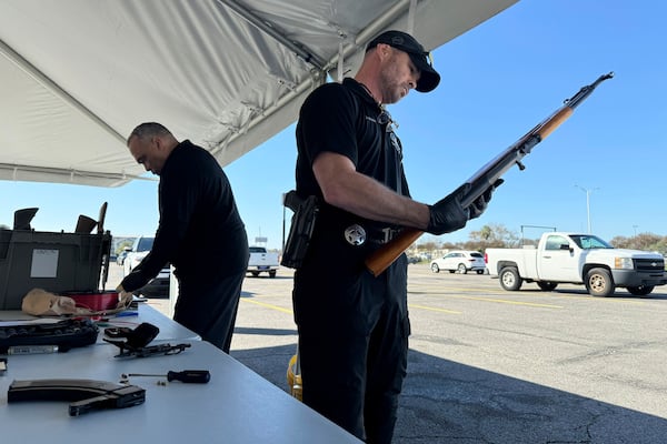 New Orleans police officer John Mciver dismantles a firearm handed over as part of a city-supported initiative exchanging guns for PlayStations, Tuesday, Dec. 31, 2024, in New Orleans. (AP Photo/Jack Brook)