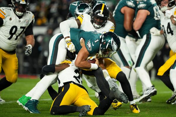 Philadelphia Eagles quarterback Jalen Hurts (1) is tackled by Pittsburgh Steelers' Patrick Queen (6) and Damontae Kazee (23) during the first half of an NFL football game Sunday, Dec. 15, 2024, in Philadelphia. (AP Photo/Matt Slocum)