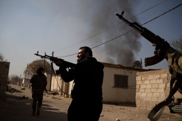 Syrian fighters aims their weapons in direction of suspected looters at a residential complex of former Bashar Assad's military officers at the village of Husseiniyeh, in the outskirts of Damascus, Syria, Sunday, Dec. 15, 2024. (AP Photo/Leo Correa)