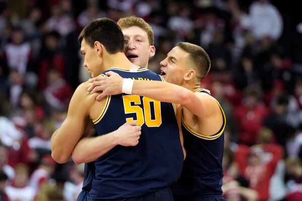 Michigan center Vlad Goldin (50) celebrates with teammates Michigan center Danny Wolf (center) and Michigan forward Will Tschetter (right) after winning 67-64 over Wisconsin in an NCAA college basketball game Tuesday, Dec. 3, 2024, in Madison, Wis. (AP Photo/Kayla Wolf)