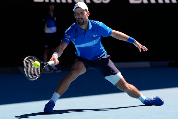 Novak Djokovic of Serbia plays a forehand return to Alexander Zverev of Germany during their semifinal match at the Australian Open tennis championship in Melbourne, Australia, Friday, Jan. 24, 2025. (AP Photo/Ng Han Guan)