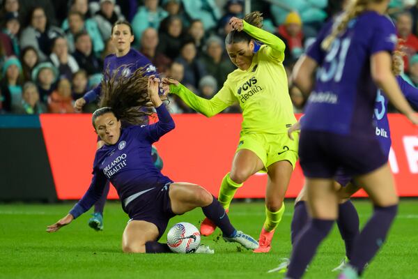 Orlando Pride defender Kerry Abello, left, and Washington Spirit forward Trinity Rodman, right, battle for the ball during the first half of the NWSL championship at CPKC Stadium, Saturday, November 23, 2024, in Kansas City, Mo. (AP Photo/Reed Hoffmann)