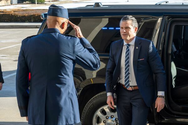 Defense Secretary Pete Hegseth, center, is welcomed to the Pentagon by Chairman of the Joint Chiefs of Staff Gen. Charles Q. Brown Jr., Monday, Jan. 27, 2025 in Washington. (AP Photo/Kevin Wolf)