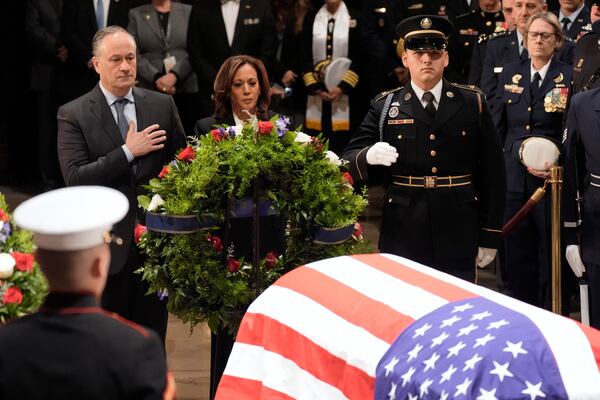 Second gentleman Doug Emhoff, from left, and Vice President Kamala Harris place a wreath at the flag-draped casket of former President Jimmy Carter during a ceremony where Carter lies in state at the Capitol in Washington, Tuesday, Jan. 7, 2025. Carter died Dec. 29 at the age of 100. (AP Photo/J. Scott Applewhite, Pool)