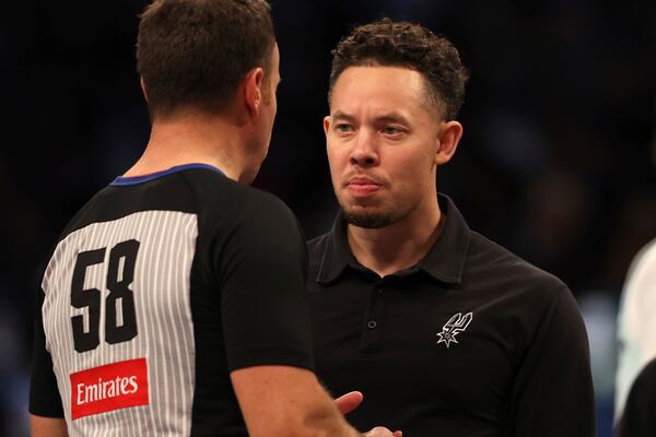 San Antonio Spurs' acting head coach Mitch Johnson, right, speaks to a referee during the second half of an NBA basketball game against the Brooklyn Nets Friday, Dec. 27, 2024, in New York. (AP Photo/Pamela Smith)