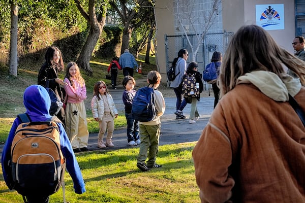 Palisades Charter Elementary School students and their parents arrive at their new school, the Brentwood Elementary Science Magnet school in the Brentwood section of Los Angeles on Wednesday, Jan. 15, 2025. (AP Photo/Richard Vogel)