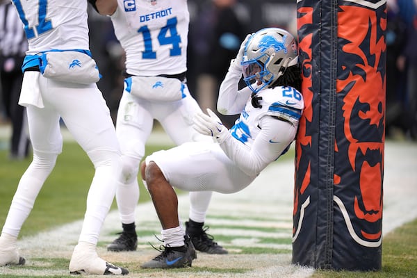 Detroit Lions running back Jahmyr Gibbs, right, celebrates his touchdown with Amon-Ra St. Brown (14) and Tim Patrick during the first half of an NFL football game against the Chicago Bears on Sunday, Dec. 22, 2024, in Chicago. (AP Photo/Erin Hooley)