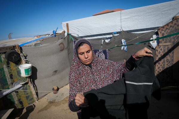 Wafaa Nasrallah hangs her laundry outside her tent at a camp for displaced Palestinians in Deir al-Balah, Gaza Strip, Saturday Dec. 28, 2024. (AP Photo/Abdel Kareem Hana)