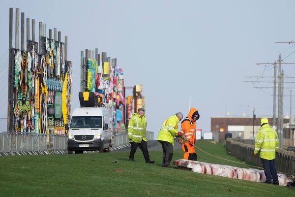 Workers secure boards from the wind as Storm Eowyn hits the country in Blackpool, England, Friday, Jan. 24, 2025.(AP Photo/Jon Super)