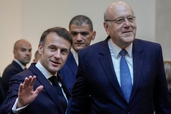 French President Emmanuel Macron gestures after his meeting with Lebanese caretaker Prime Minister Najib Mikati, right, upon his arrival at Beirut's Rafic Hariri International Airport in Beirut, Lebanon, Friday, Jan. 17, 2025. (AP Photo/Hassan Ammar)