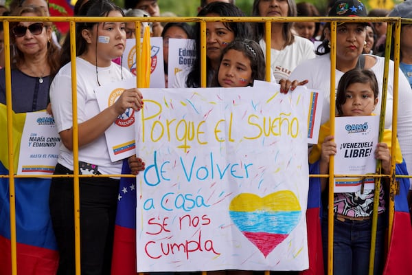 Supporters of Venezuela's opposition leader Edmundo Gonzalez Urrutia hold a banner reading in Spanish" Because the dream of returning home comes true" outside the government residence where he meets with Uruguayan President Luis Lacalle Pou in Montevideo, Uruguay, Saturday, Jan. 4, 2025. Gonzalez, who claims he won the 2024 presidential election and is recognized by some countries as the legitimate president-elect, traveled from exile in Madrid to Argentina and Uruguay. (AP Photo/Matilde Campodonico)