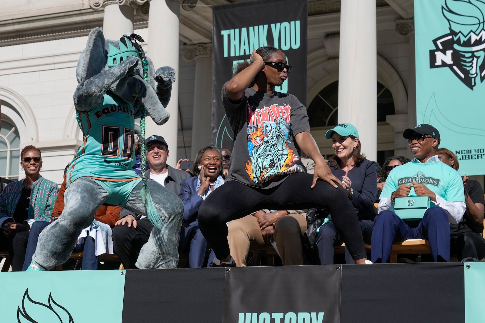 New York Liberty Kennedy Burke dances with the mascot, Ellie the Elephant, during a ceremony after a parade in honor of the Liberty's WNBA basketball championship at City Hall in New York, Thursday, Oct. 24, 2024. (AP Photo/Seth Wenig)