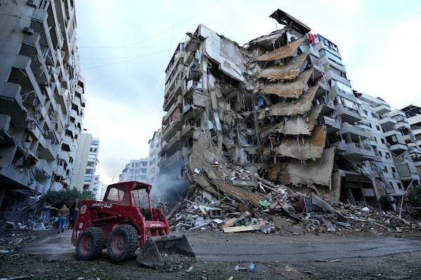 A Civil Defense worker uses a skid loader to remove the rubble in front of a destroyed building that was hit Sunday night in an Israeli airstrike in Dahiyeh, in the southern suburb of Beirut, Lebanon, Monday, Nov. 25, 2024. (AP Photo/Hussein Malla)