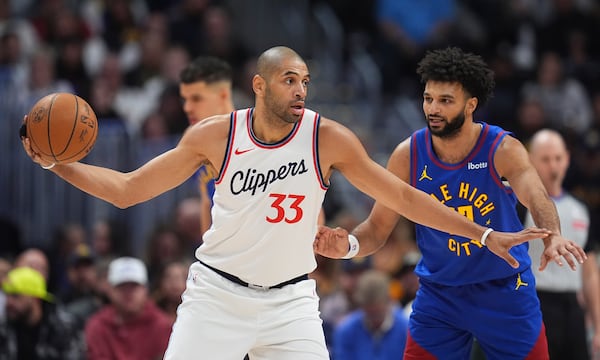 Los Angeles Clippers forward Nicolas Batum, left, looks to pass the ball as Denver Nuggets guard Jamal Murray defends in the first half of an NBA basketball game Wednesday, Jan. 8, 2025, in Denver. (AP Photo/David Zalubowski)