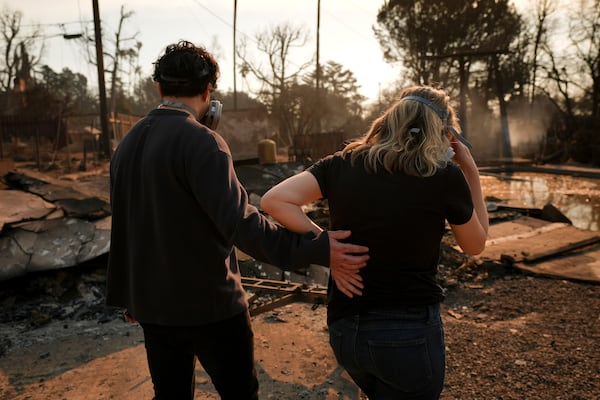 Homeowners Sohrab Nafici, left, and Christine Meinders return to their fire-ravaged neighborhood in the aftermath of the Eaton Fire Friday, Jan. 10, 2025 in Altadena, Calif. (AP Photo/Jae C. Hong)