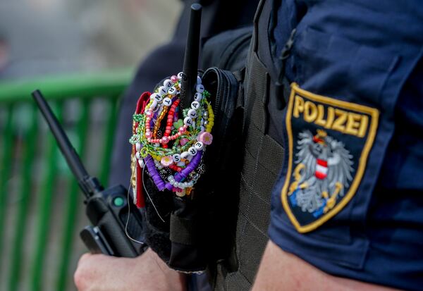 FILE - A police officer is decorated with Taylor Swift bracelets while guarding the city center in Vienna on Aug.8, 2024. (AP Photo/Heinz-Peter Bader, File)