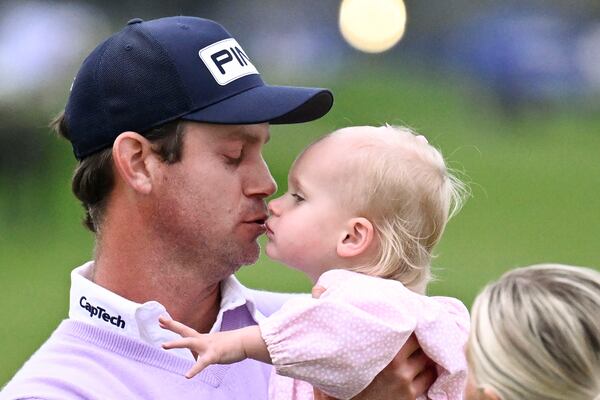 Harris English kisses his daughter Emilia English as his wife Helen Marie English looks on after winning the Farmers Insurance Open golf tournament at Torrey Pines Saturday, Jan. 25, 2025, in San Diego. (AP Photo/Denis Poroy)