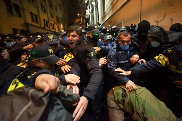 Police try to push out protesters after they pour into the streets following Georgian Prime Minister Irakli Kobakhidze's announcement, rallying outside the parliament building in Tbilisi, Georgia, on Thursday, Nov. 28, 2024. (AP Photo/Zurab Tsertsvadze)