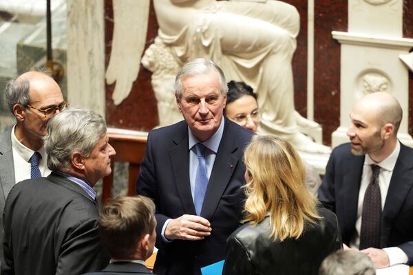 French Prime Minister Michel Barnier, center, talks to people at the National Assembly before French lawmakers vote on a no-confidence motion that could bring down the prime minister and the government for the first time since 1962, Wednesday, Dec. 4, 2024 in Paris. (AP Photo/Michel Euler)