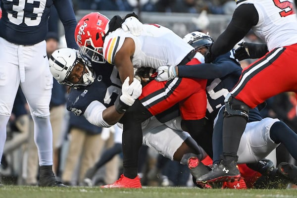 Penn State defensive tackle Zane Durant, center left, sacks Maryland quarterback MJ Morris, center top, during the first quarter of an NCAA college football game, Saturday, Nov. 30, 2024, in State College, Pa. (AP Photo/Barry Reeger)