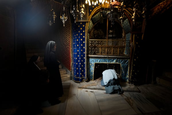 Worshippers pray at the Church of the Nativity, traditionally believed to be the birthplace of Jesus, on Christmas Eve, in the West Bank city of Bethlehem, Tuesday, Dec. 24, 2024. (AP Photo/Matias Delacroix)