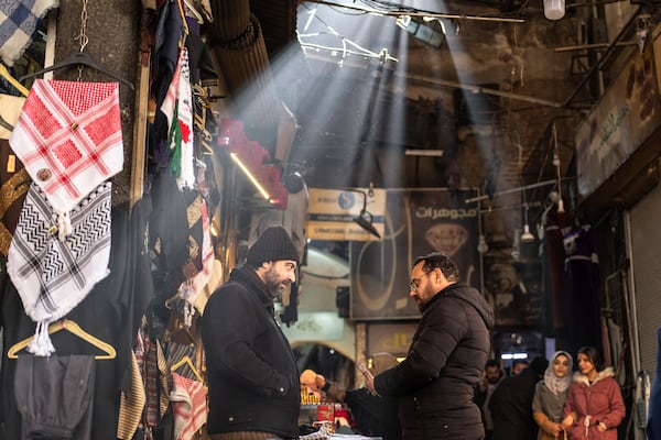 Shop owners talk while they wait for clients in Al-Hamidiyeh Souq on New Years Eve, in Damascus, Syria, Tuesday, Dec. 31, 2024. (AP Photo/Mosa'ab Elshamy)