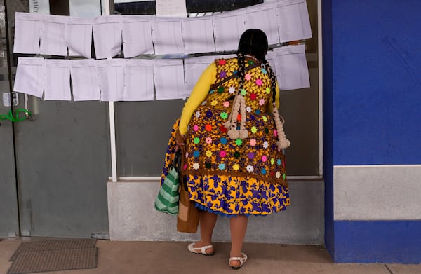 A voter searches for her polling station during judicial elections in Guaqui, Bolivia, Sunday, Dec. 15, 2024. (AP Photo/Juan Karita)