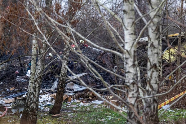 Lithuanian Emergency Ministry employees work near the site where a DHL cargo plane crashed into a house near the Lithuanian capital Vilnius, Lithuania, Lithuania, Monday, Nov. 25, 2024. (AP Photo/Mindaugas Kulbis)