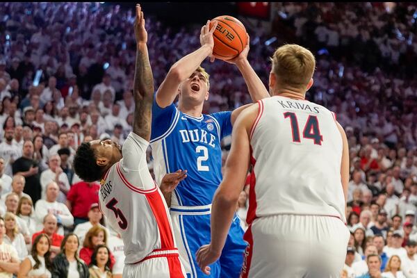 Duke guard Cooper Flagg (2) is double-teamed by Arizona guard KJ Lewis (5) and Motiejus Krivas (14) during the first half of an NCAA college basketball game Friday, Nov. 22, 2024, in Tucson, Ariz. (AP Photo/Darryl Webb)