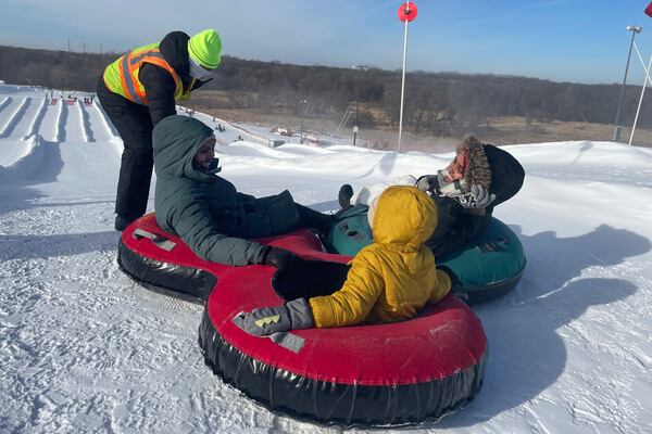 Nasrieen Habib, left, seated, her son, center, and Makiya Amin go snow tubing during an outing organized by the group Habib founded to promote outdoors activities among Muslim women, at Elm Creek Park Reserve in Maple Grove, Minn., on Jan. 4, 2025. (AP Photo/Giovanna Dell'Orto)