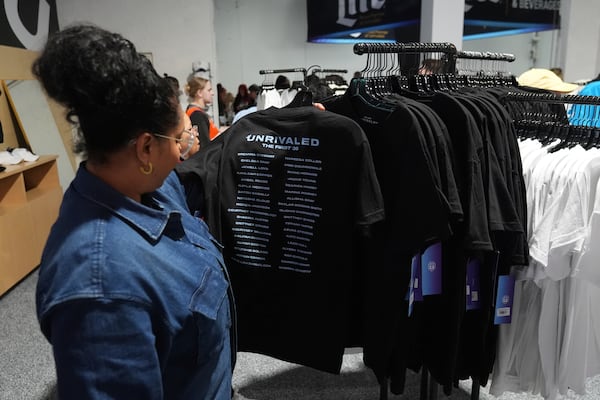 Bri Hamilton of Los Angeles, looks at merchandise before the Unrivaled 3-on-3 women's basketball game between Lunar Owls and Mist, Friday, Jan. 17, 2025, in Medley, Fla. (AP Photo/Marta Lavandier)