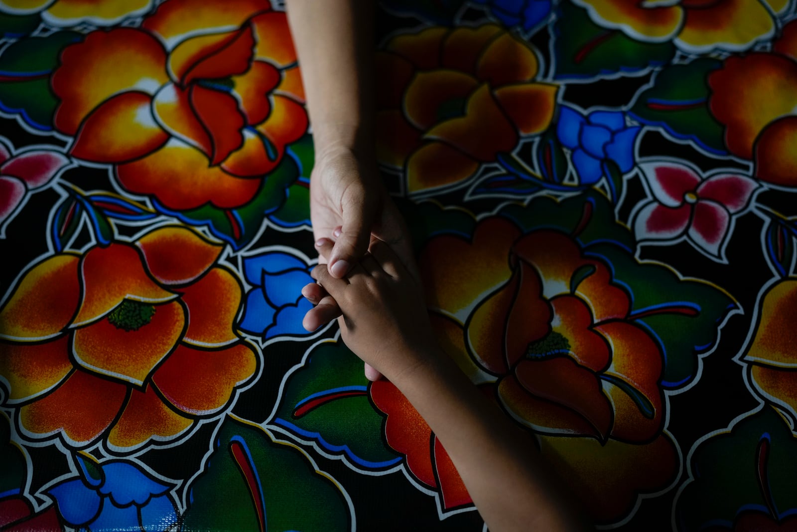 Venezuelan migrant Eyla Fonseca holds her son's hand during breakfast at the Casa del Migrante shelter in Tecun Uman, Guatemala, Sunday, Oct. 27, 2024. (AP Photo/Matias Delacroix)