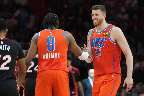 Oklahoma City Thunder forward Jalen Williams (8) and center Isaiah Hartenstein (55) celebrate during a timeout during the second half of an NBA basketball game against the Miami Heat, Friday, Dec. 20, 2024, in Miami. (AP Photo/Marta Lavandier)