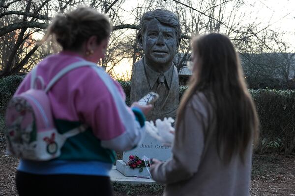 People visit a bust of former President Jimmy Carter at the Jimmy Carter Presidential Library and Museum on Sunday, Dec. 29, 2024, in Atlanta. (AP Photo/Brynn Anderson)