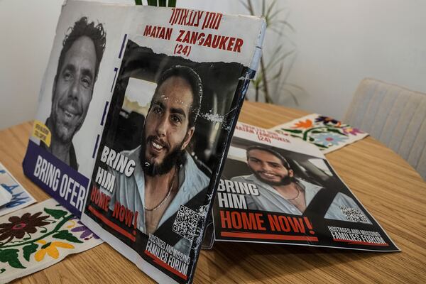 Photos of Matan Zangauker, held hostage by Hamas in the Gaza Strip, are displayed on a table in the apartment of his girlfriend, released hostage Ilana Gritzewsky, in Kiryat Gat, Israel, Sunday, Dec. 15, 2024. (AP Photo/Tsafrir Abayov)