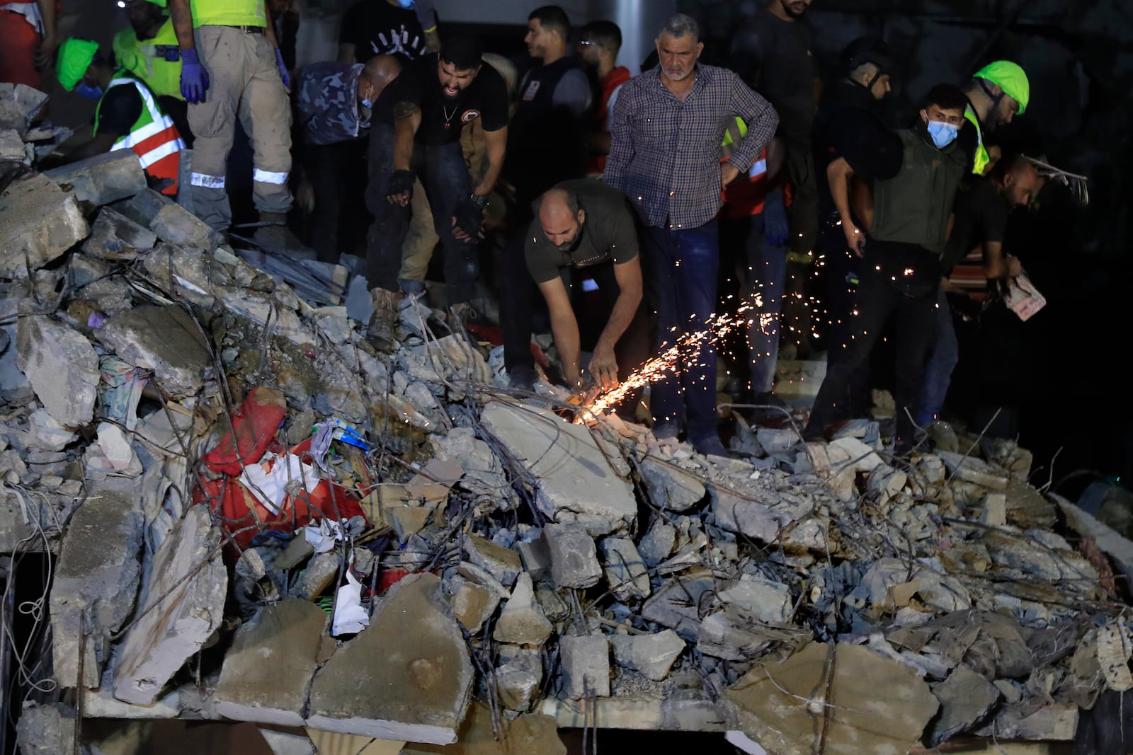 Rescue workers search for victims at a destroyed building hit in an Israeli airstrike, in the southern port city of Sidon, Lebanon, Tuesday, Oct. 29, 2024. (AP Photo/Mohammed Zaatari)