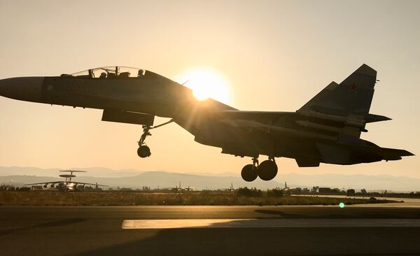 FILE - A Russian military jet lands at sunrise at Hemeimeem air base in Syria on Sept. 12, 2017. (AP Photo/Nataliya Vasilyeva, File)