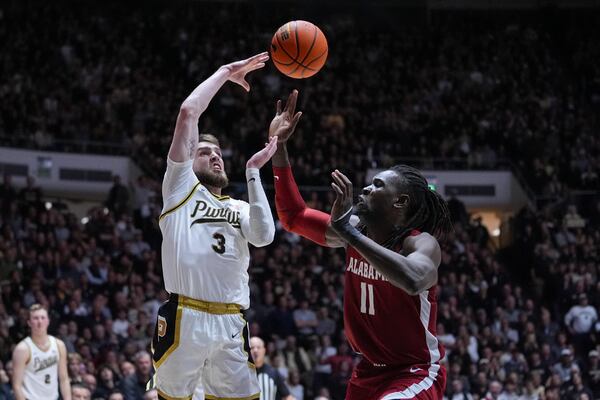 Purdue guard Braden Smith (3) makes a pass over Alabama center Clifford Omoruyi (11) during the second half of an NCAA college basketball game in West Lafayette, Ind., Friday, Nov. 15, 2024. (AP Photo/Michael Conroy)