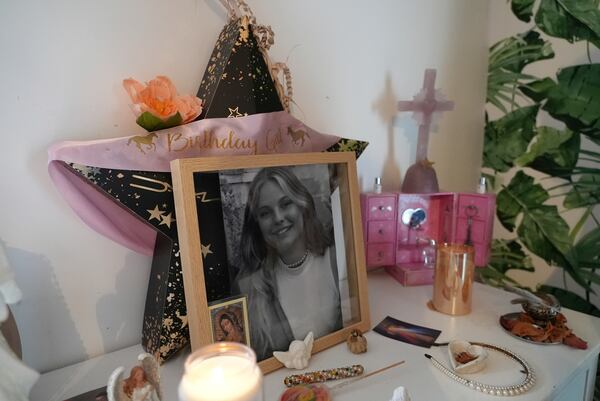 A black and white photo of Marie Le Tiec, a teenager who died by suicide in 2021, is seen alongside candles and religious items in her bedroom, on Dec. 10, 2024, in Cassis, southern France. (AP Photo/Tom Nouvian)