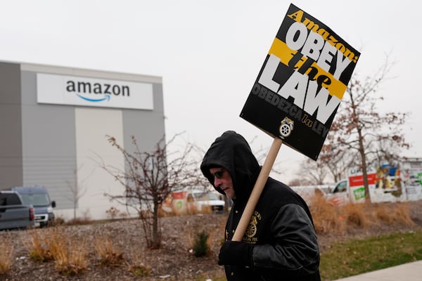 A striker holds a sign during a strike at Skokie (DIL7) Amazon Delivery station in Skokie, Ill., Thursday, Dec. 19, 2024. (AP Photo/Nam Y. Huh)