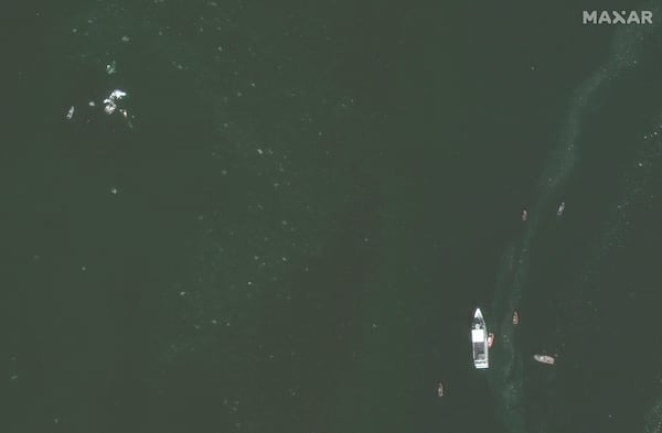 This satellite image provided by Maxar Technologies shows recovery efforts around the wreckage site in the Potomac River from Ronald Reagan Washington National Airport, Thursday, Jan. 30, 2025, near Arlington, Va. (Maxar Technologies via AP)