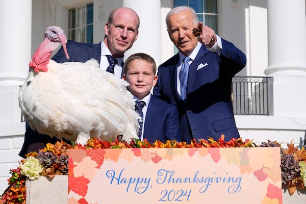 President Joe Biden, right, stands with John Zimmerman, left, chair of the National Turkey Federation, his son Grant Zimmerman, center, and the national Thanksgiving turkey, Peach, during a pardoning ceremony on the South Lawn of the White House in Washington, Monday, Nov. 25, 2024. (AP Photo/Susan Walsh)