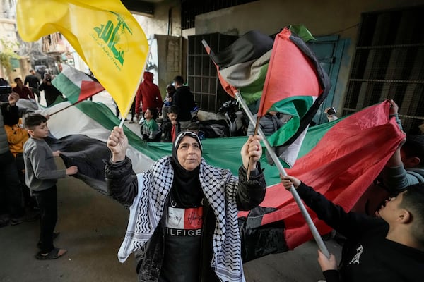 Palestinians wave Hezbollah and Palestinian flags to celebrate a ceasefire agreement between Hamas and Israel at the Burj al-Barajneh Palestinian refugee camp, south of Beirut, Lebanon, Sunday, Jan. 19, 2025. (AP Photo/Hassan Ammar)